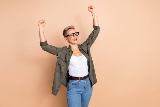 Portrait of delighted positive person closed eyes raise fists accomplishment isolated on beige color background. - Photo, Image