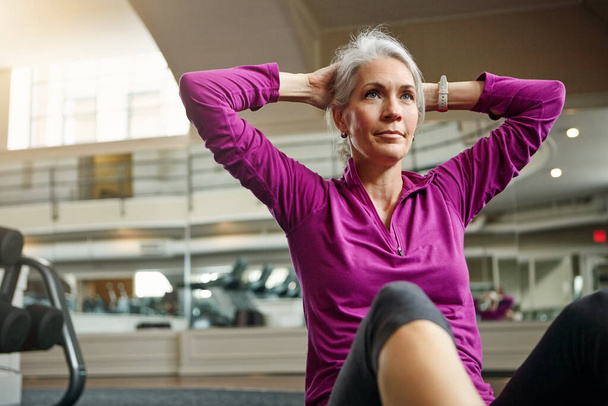Mit ihren gesunden Gewohnheiten Schritt halten. eine reife Frau trainiert im Fitnessstudio - Foto, Bild