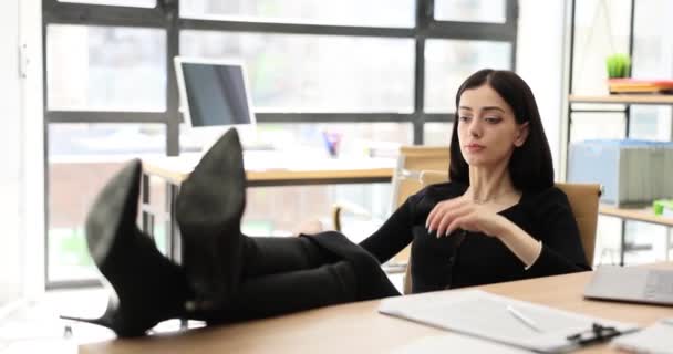 Kalme dromerige jonge zakenvrouw neemt pauze afwerkingen werk houdt haar voeten op tafel. Manager voelt geen stress op de werkplek - Video