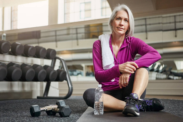 Die Bedeutung der Gesundheit nimmt mit zunehmendem Alter zu. Porträt einer reifen Frau beim Training im Fitnessstudio - Foto, Bild