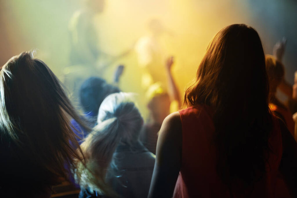 Müzik konseri, kalabalık ve insanlar parti ışıkları, dans ve tezahüratlarla genel z festivali için gece şarkı söylüyorlar. Etkinlikte sahnede rock grubu ve kalabalık dansı, seyirci arkası veya kadın hayranları. - Fotoğraf, Görsel