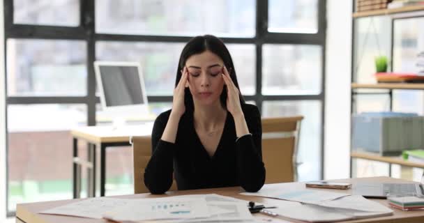 Unavená podnikatelka s těžkou bolestí hlavy masírující spánky na pracovišti. Vyčerpané přepracování unavená žena manažer v kanceláři - Záběry, video