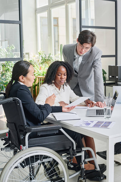 Азійська бізнесменка з інвалідністю працює зі своїми колегами на зустрічі в офісі. - Фото, зображення