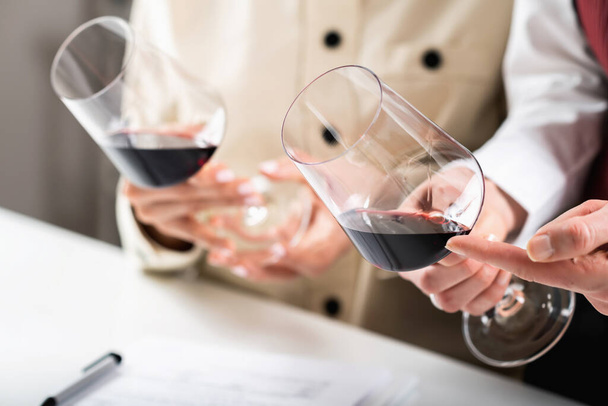 Ochutnávka červeného vína. Účastníci porovnat barvy různých červených vín v degustační akce, naučit se identifikovat stáří vína, odrůdy hroznů, a další klíčové detaily na základě odstínu. - Fotografie, Obrázek