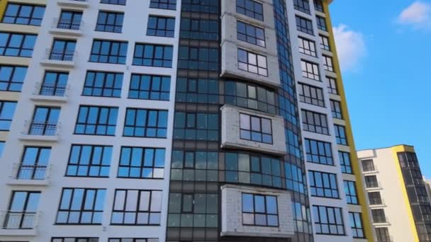 Edifício de apartamentos residenciais altos com moldura monolítica e janelas de vidro em construção. Desenvolvimento imobiliário. - Filmagem, Vídeo