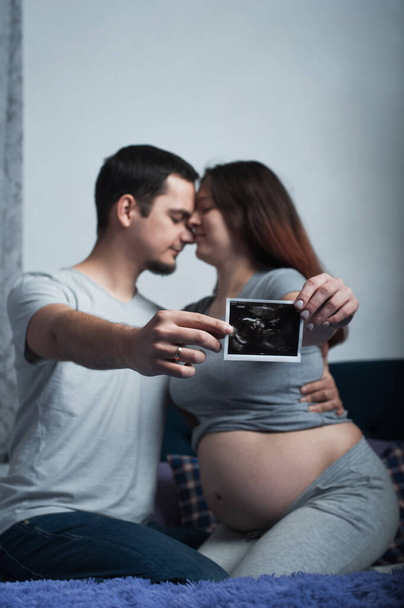 Liebespaar in Erwartung von Baby hält Ultraschalluntersuchung ab. - Foto, Bild