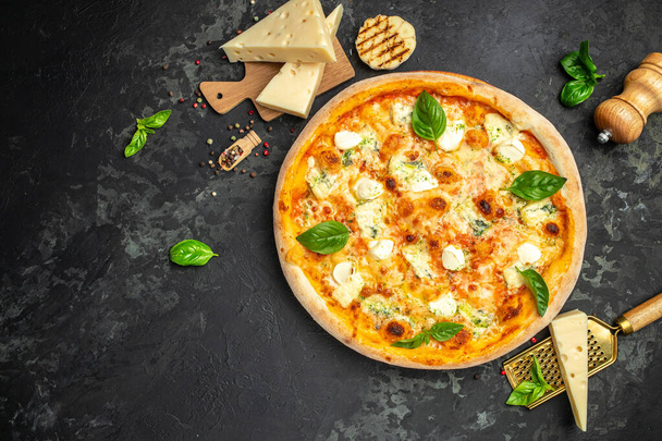 four cheese pizza, homemade italian pizza. Pizza on rustic black background. Traditional italian cuisine. place for text, top view. - Photo, Image
