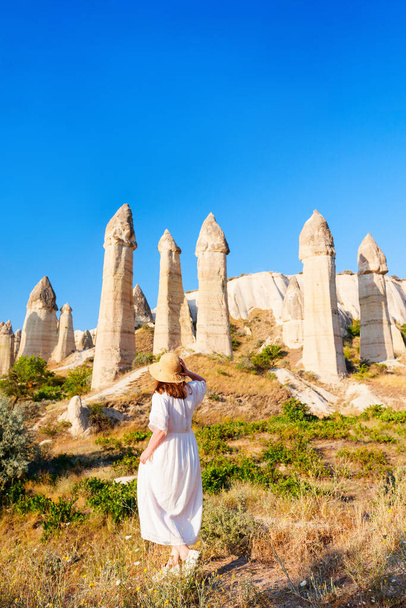 Young woman walking in Love valley in Cappadocia Turkey among rock formations and fairy chimneys - Photo, image