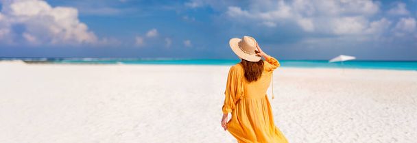 Young woman on white sand tropical beach in Maldives enjoying vacation - Foto, Imagen