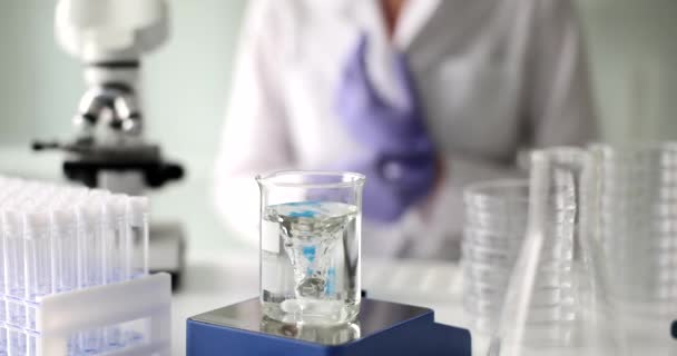 Διαφανές υγρό νερό σε γυάλινη φιάλη και μαγνητικό καθαρισμό του νερού. Εργαστηριακή και χημική ανάλυση του νερού - Πλάνα, βίντεο