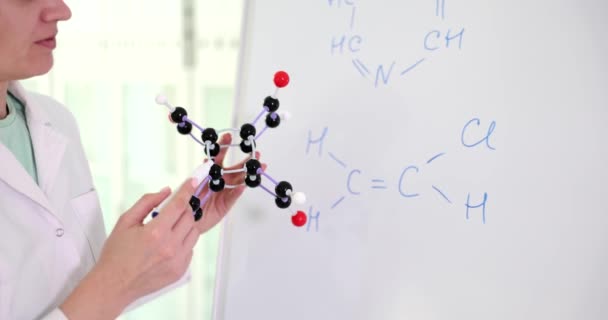 La mano química sostiene moléculas átomos dibuja fórmulas en pizarra. Fórmula molecular y sustancias en química - Imágenes, Vídeo