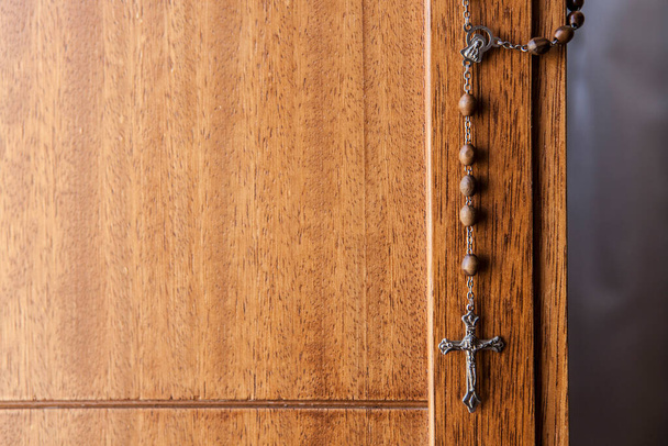 Katolikus rózsafüzér lóg fa ajtó. Szelektív fókusz - Fotó, kép
