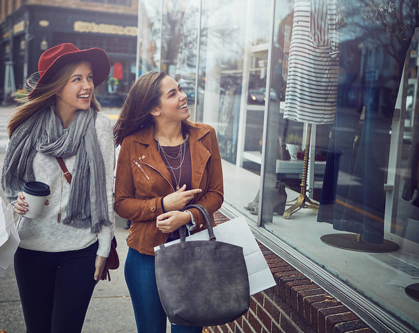 Ez jól néz ki. Két fiatal barátnő sétálgat a belvárosban, miközben bevásárolnak. - Fotó, kép