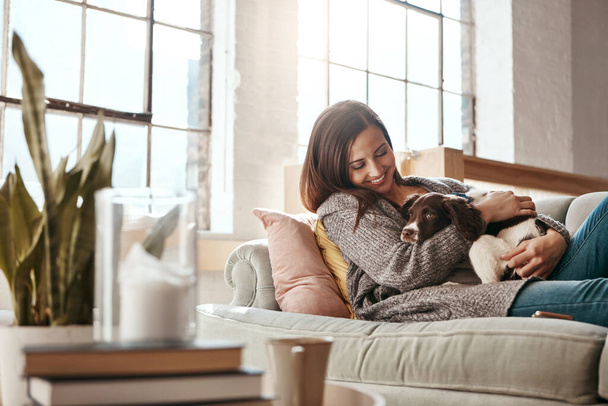 A felicidade é um cachorrinho quente. uma jovem atraente relaxando em casa no fim de semana - Foto, Imagem