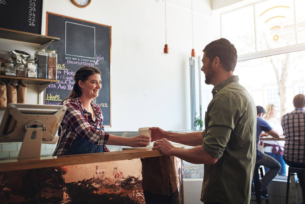 Il servizio superiore è semplicemente una parte del lavoro. una cameriera che serve caffè a un cliente in un caffè - Foto, immagini