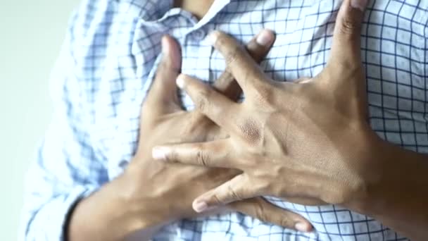 jonge man lijden pijn in het hart en houden borst met de hand . - Video