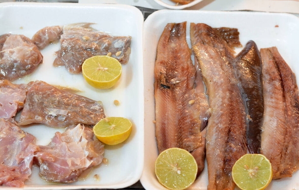 Παραδοσιακό γεύμα Fesikh το οποίο έχει υποστεί ζύμωση, αλατισμένο και αποξηραμένο γκρίζο μπαρμπούνι του γένους Mugil και τεμάχια φιλέτων καπνιστών ρέγγας και μαλακών ζαριών παρασκευασμένων με λάδι και λεμόνι - Φωτογραφία, εικόνα