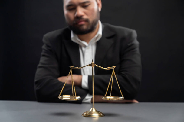 Фокус золотого масштабу балансу з підпаленим тлом адвоката в чорному костюмі сидить на його офісному столі, символ правосуддя і цілісності, збалансоване і етичне рішення в суді правової рівності
 - Фото, зображення
