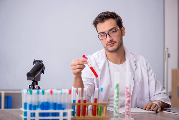 Young chemist in front of white board - Photo, Image