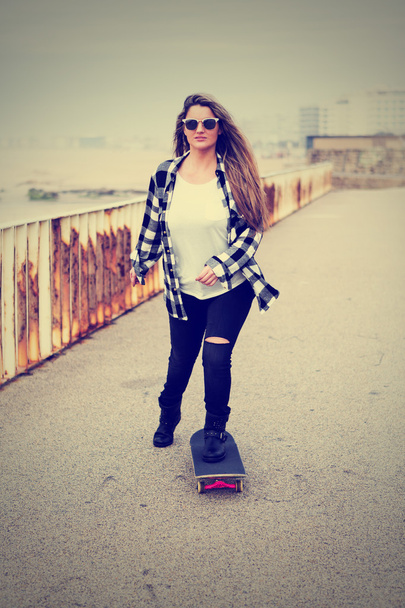 Mooie vrouw met skateboard - Foto, afbeelding