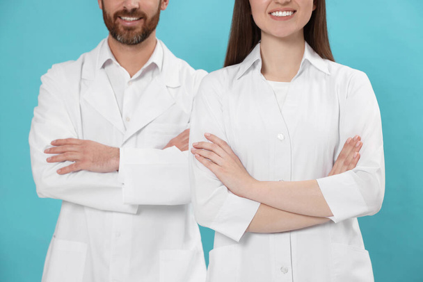 Nurses in medical uniform on light blue background, closeup - Фото, изображение