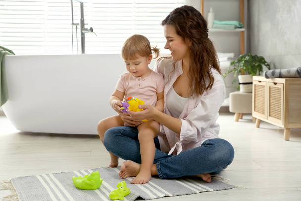 Mother playing with her daughter in bathroom - Photo, image