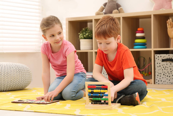 Niños jugando con kits de juego de matemáticas en el piso de la habitación. Aprender matemáticas con diversión - Foto, imagen
