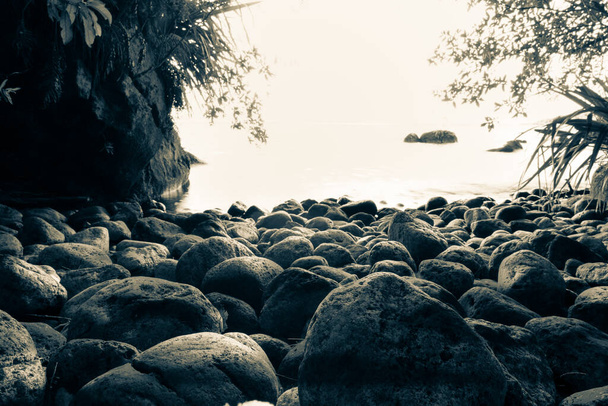 Las rocas en las aguas se juntan en una pequeña bahía sombreada con un enfoque selectivo en piedras cerradas. - Foto, imagen