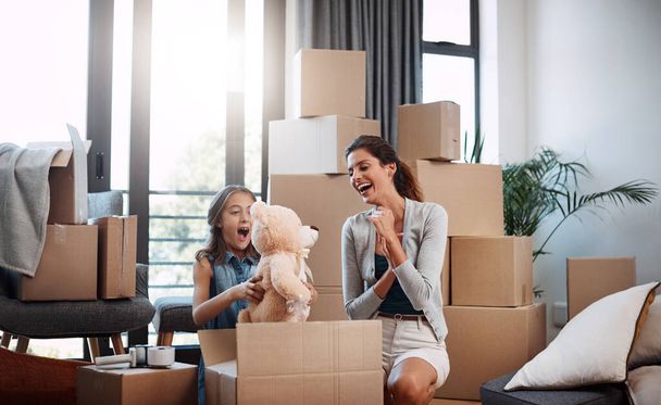 You packed Mr Teddy. an attractive young woman and her daughter moving into a new house - Zdjęcie, obraz
