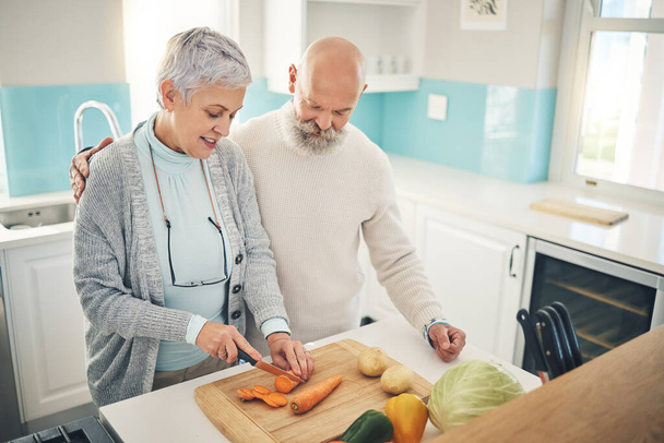 Koken, eten en een oud echtpaar in de keuken van hun huis samen tijdens de pensionering voor maaltijdbereiding. Gezondheid, welzijn of voeding met een oudere man en vrouw die avondeten maken in hun huis. - Foto, afbeelding