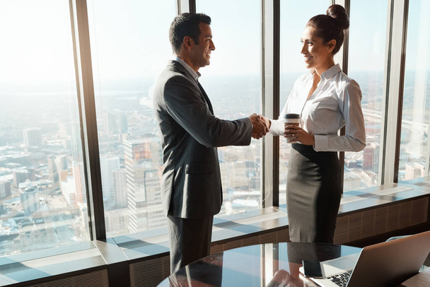 I look forward to what well achieve together. two businesspeople shaking hands in an office - Фото, изображение
