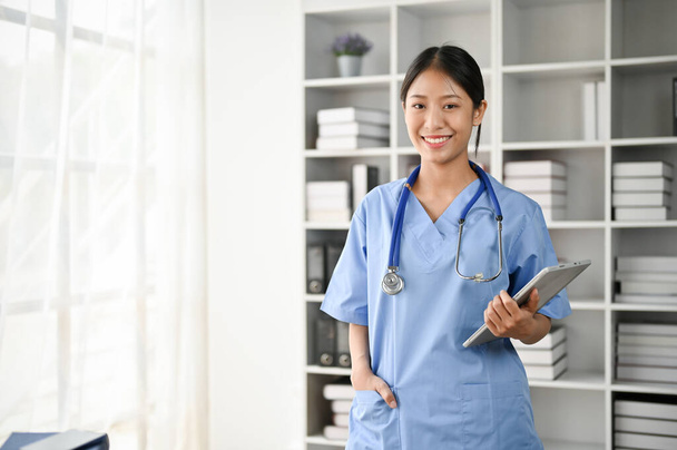 若いアジアの医学生の笑顔と彼女の手にタブレットを保持しながら、研究室に立っての肖像画  - 写真・画像