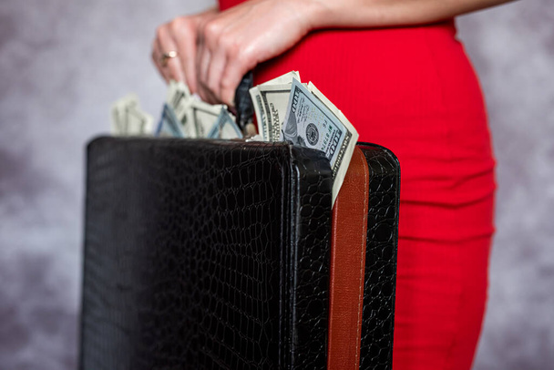 Closeup of female holding briefcase with money as bribery. Corruption illegal concept  - Fotó, kép