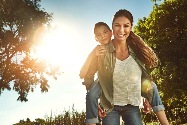 Nuestro combo favorito es el sol y los momentos divertidos. Retrato de una madre y su hija uniéndose al aire libre - Foto, imagen