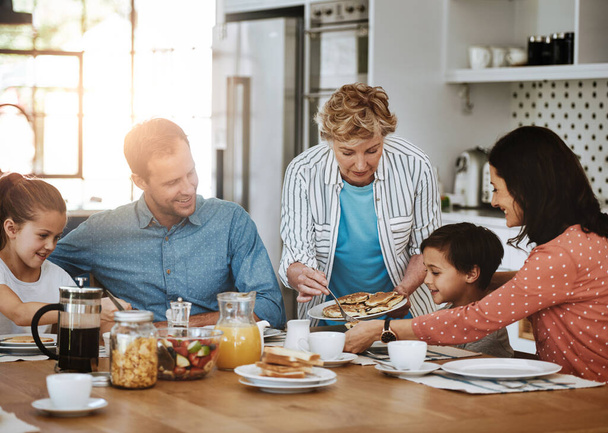 Mummi tekee parhaita pannukakkuja. monen sukupolven perhe nauttimassa aamiaista yhdessä kotona - Valokuva, kuva