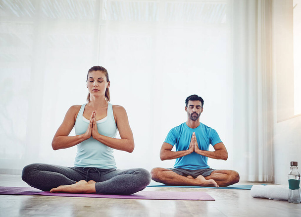 La méditation traîne avec ton âme. un couple pratiquant le yoga à la maison - Photo, image