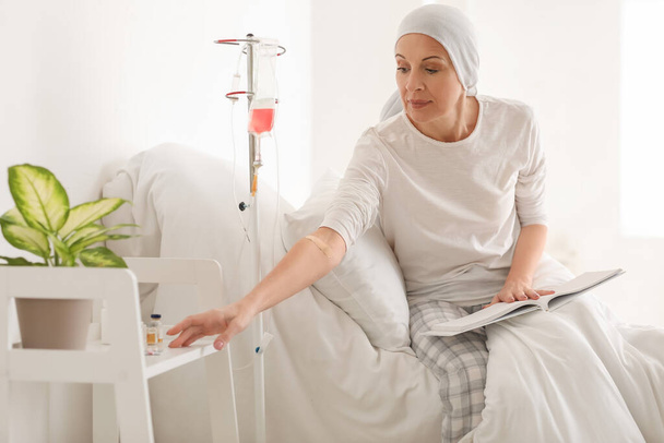 Femme mûre après une chimiothérapie prenant des médicaments en clinique - Photo, image
