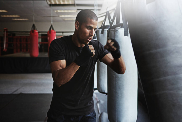 I fight for perfection. a kick-boxer training in a gym - Zdjęcie, obraz