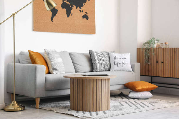 Interiér stylového obývacího pokoje s útulnou pohovkou a moderním notebookem na konferenčním stolku - Fotografie, Obrázek