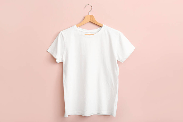White t-shirt hanging on pink wall - Foto, afbeelding