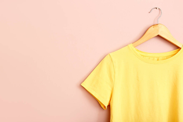 Żółta koszulka wisząca na różowej ścianie - Zdjęcie, obraz