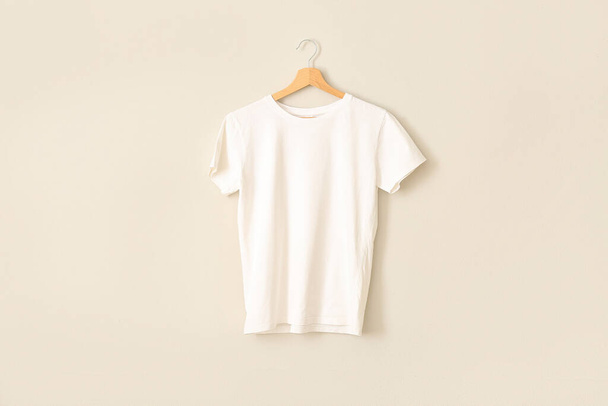 White t-shirt hanging on grey wall - 写真・画像