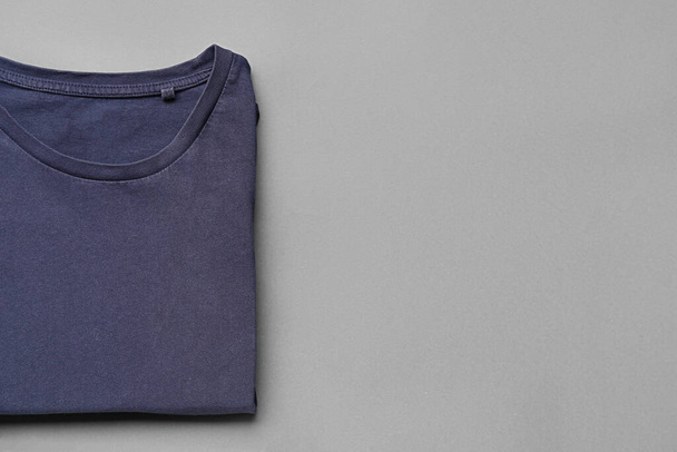 Folded blue t-shirt on grey background - Zdjęcie, obraz