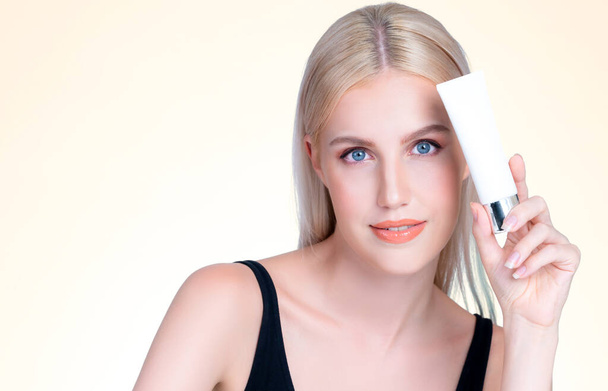 Zbliżenie piękny idealny naturalny makijaż kosmetyczny skóry kobieta trzyma krem nawilżający tubkę do zdrowej pielęgnacji skóry leczenie, anti-aging reklama produktu w izolowanym tle. - Zdjęcie, obraz