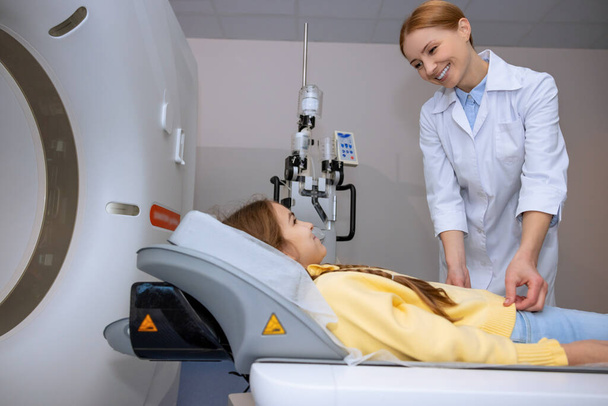 Médecin féminin effectuant une IRM de l'enfant, faisant une tomographie pour l'enfant, examinant la santé de la petite fille dans une clinique moderne. - Photo, image