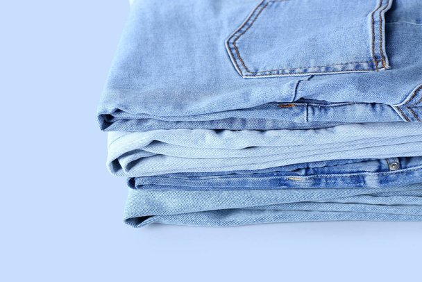 Stack of jeans on light background, closeup - Foto, afbeelding