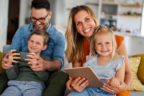 Happy family spending time at home and using digital devices together. Technology people fun concept. - Valokuva, kuva