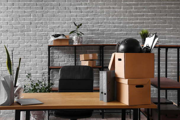 Рабочее место с картонными коробками в офисе в день переезда - Фото, изображение