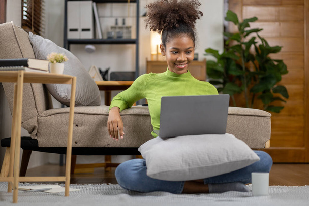 Een Amerikaanse tienervrouw is in de woonkamer, ze brengt haar weekends thuis door met het spelen van sociale media en het kijken naar films. Het concept van leven op vakantie. - Foto, afbeelding
