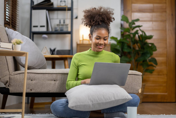 Amerikalı genç bir kadın oturma odasında, hafta sonlarını evde sosyal medya oynayarak ve film izleyerek geçiriyor. Tatilde yaşama kavramı. - Fotoğraf, Görsel